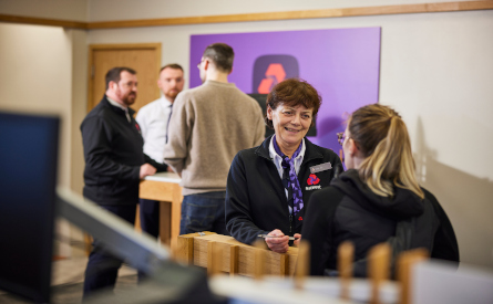 This image shows NatWest colleagues in a branch serving customers. 