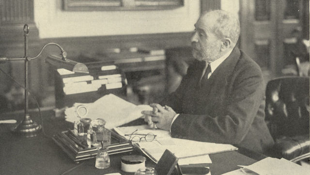 Photograph of Sir Felix Schuster at his desk Photograph of Sir Felix Schuster at his desk