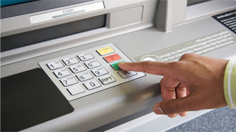 Customer at the keypad of an ATM