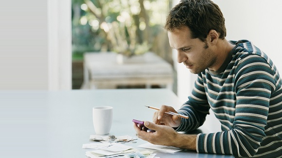 Man managing debt using mobile banking