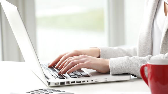 women typing on laptop