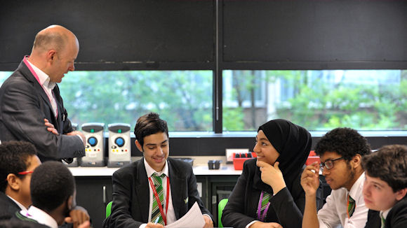 NatWest volunteer with students, teaching them about managing money with the Moneysense programme