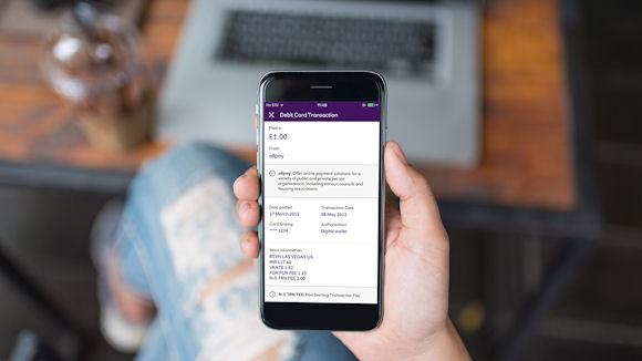 a person holding the a smart phone with the NatWest banking app open