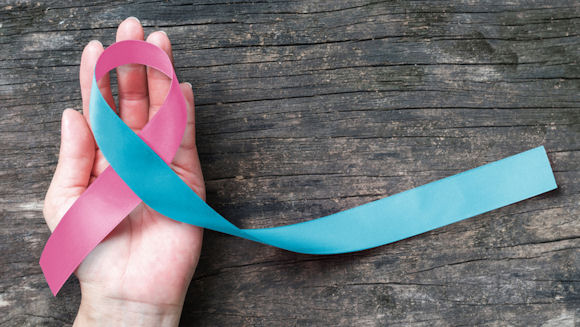 hand holding blue and pink ribbon which represents baby loss awareness